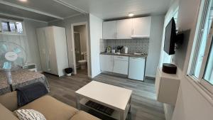 a small living room with a couch and a kitchen at Renovated Tiny House in the Country near Fataga in Artedara