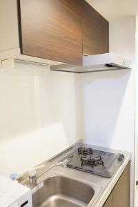 una cucina con lavandino e piano cottura di Private Hotel Summer 102 a Tokyo