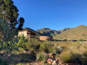 a house in a field with mountains in the background at Riverbend Farm in Robertson