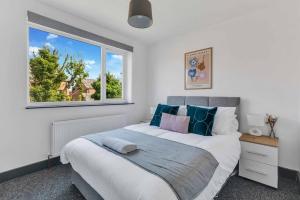 Un dormitorio con una gran cama blanca y una ventana en Silver Stag Properties, 4 BR in Ashby de la Zouch, en Smisby