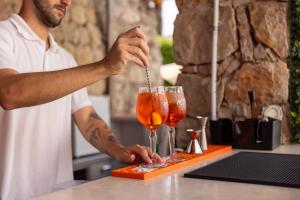 a man is preparing two cocktails on a counter at Clube do Lago Hotel in Estoril