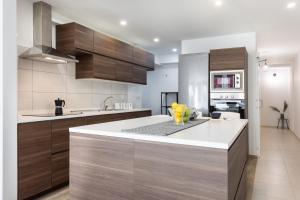 een keuken met houten kasten en een wit aanrecht bij Trinidad Avenue Premium Apartment in La Laguna