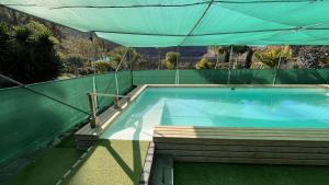 una piscina con una tettoia verde sopra di essa di Cosy Country Studio near Maspalomas and Fataga a Artedara