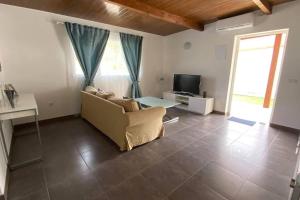 a living room with a couch and a tv at 2 Bedroom Country House Near Fataga & Maspalomas in Artedara