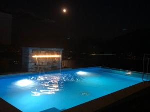 a swimming pool at night with the moon in the background at Casa Makatea in Brione sopra Minusio