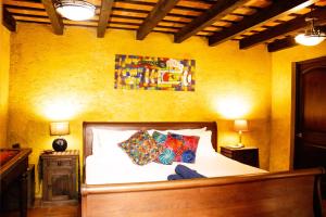 a bedroom with a bed with two pillows on it at Casa Quetzalli Centro Histórico Antigua in Antigua Guatemala +13 photos