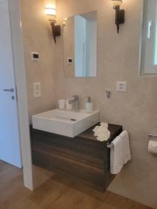 a bathroom with a white sink and a mirror at Casa Makatea in Brione sopra Minusio