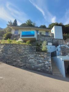 a house with a swimming pool on a stone wall at Casa Makatea in Brione sopra Minusio