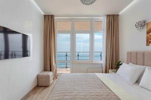a bedroom with a bed and a large window at Direct sea view in Odesa