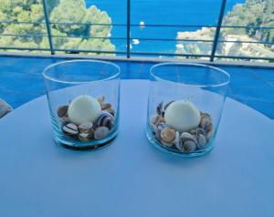 two glass vases with rocks and shells on a table at 'nni Francuzzu in Taormina