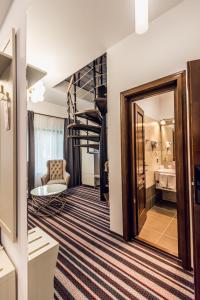 un couloir avec un escalier et une chambre avec un miroir dans l'établissement Villa Galleria, à Colibiţa