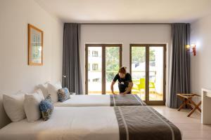 a woman in a hotel room with a large bed at Clube do Lago Hotel in Estoril