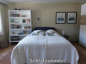 a bedroom with a white bed and bookshelves at Alte Schule Mankmuß in Karstädt