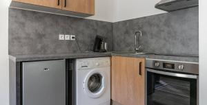 a kitchen with a washing machine and a sink at Le Coeur Ardéchois in Vals-les-Bains