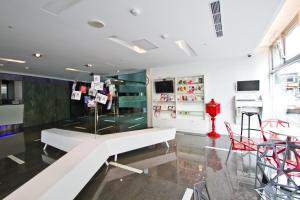 a room with a white bench and a table at HOTEL HI - Xinmin in Chiayi City