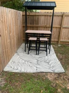 a picnic table and two chairs on a rug in a yard at D's Mississippi Vacation Home with Game room in Gulfport