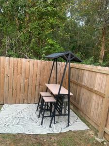 a picnic table and bench with a black umbrella at D's Mississippi Vacation Home with Game room in Gulfport