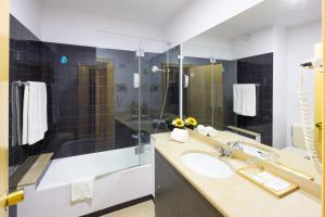 a bathroom with a sink and a large mirror at Clube do Lago Hotel in Estoril
