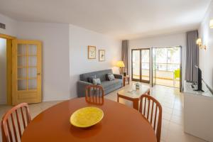 a living room with a table and chairs and a couch at Clube do Lago Hotel in Estoril