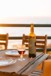 a bottle of wine sitting on a table with a glass at Alfaiate Beach House in Santa Cruz