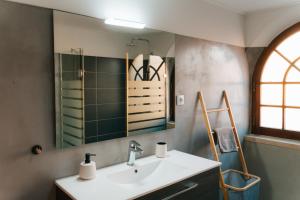 a bathroom with a sink and a mirror at Alfaiate Beach House in Santa Cruz +34 photos