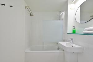 Les Chevaliers des Balances في Saint-Aubin: حمام أبيض مع حوض وحوض استحمام