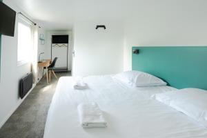 a large white bed with two white towels on it at Les Chevaliers des Balances in Saint-Aubin