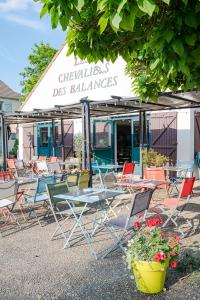 a group of chairs and tables in front of a restaurant at Les Chevaliers des Balances in Saint-Aubin