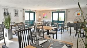 a dining room with tables and chairs and windows at Les Chevaliers des Balances in Saint-Aubin +25 photos