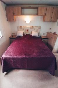 ein Schlafzimmer mit einem großen Bett mit einer roten Decke in der Unterkunft Odpocznij w Lesie 