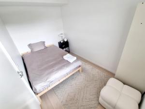 a small bedroom with a bed and a chair at Private room in shared Modern Apartment - Oslo Hideaway in Oslo