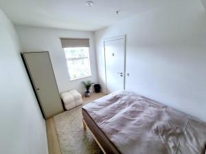 Private room in shared Modern Apartment - Oslo Hideaway في أوسلو: غرفة نوم بسرير ونافذة ومرآة
