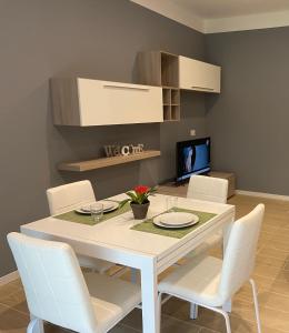 a dining room with a white table and white chairs at Casa di Laura mono e bilo di fronte Ospedale San Raffaele in Segrate