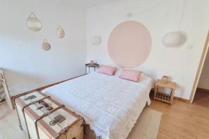 Habitación blanca con cama con almohadas rosas en La Planque/Terrasse - entre Nîmes/Pont du Gard, en Marguerittes