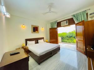 1 dormitorio con cama, escritorio y ventana en BedChambers Serviced Apartments - Artemis Hospital, en Gurgaon