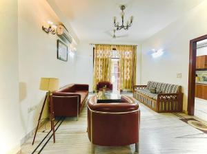 a living room with leather chairs and a table at BedChambers Serviced Apartments - Artemis Hospital in Gurgaon