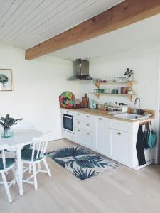 a kitchen with white cabinets and a table with a sink at Loft atypique pour 2 personnes in Nieulle-sur-Seudre