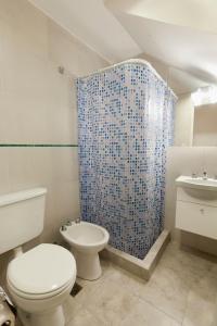 łazienka z toaletą i niebieską zasłoną prysznicową w obiekcie Civitella Appart w mieście Villa Mercedes