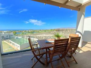 un tavolo e sedie su un balcone con vista sulla spiaggia di Nuevo Ático Toyo. Vistas al mar, terraza, solarium, piscina, A/A, WiFi y Garaje a El Toyo