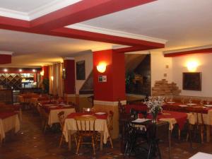 a restaurant with tables and chairs and red walls at Favila Oviedo in Oviedo