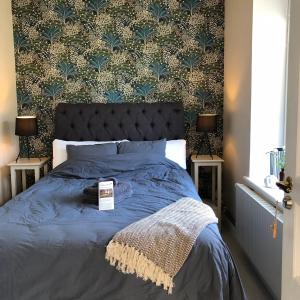 a bedroom with a bed with a blue comforter and a wall at Tullesbo Sätesgård in Sjöbo