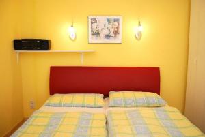 een slaapkamer met een bed met een rood hoofdeinde bij Ferienpark am Darß - Ferienhaus 3 in Fuhlendorf