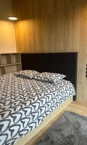 1 dormitorio con 1 cama con edredón blanco y negro en Apartament ONE Szklarska Poręba, en Szklarska Poręba