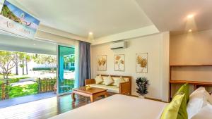 a bedroom with a bed and a couch and a table at Aura Samui Best Beach Hotel - SHA Plus in Lamai