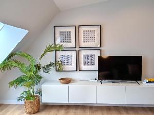 ein Wohnzimmer mit einem TV auf einem weißen Schrank in der Unterkunft Príncipe Boutique apartments in Vigo