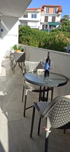 a table with a bottle of wine on a balcony at Apartments Desa Petric in Hvar