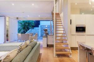 a living room with a couch and a staircase at Clifton 4th Beach Villa 6 Sleeper in Cape Town