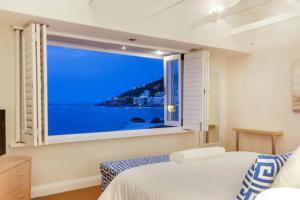a bedroom with two beds and a large window at Clifton 4th Villa in Cape Town +2 photos