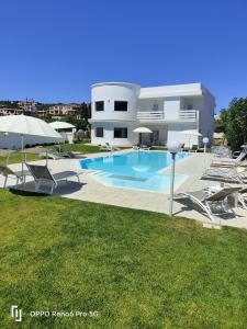 a house with a swimming pool with chairs and umbrellas at Al Mare da Francesca in Olbia