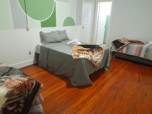 een kamer met een bed in een kamer met houten vloeren bij Hotel Palace City Agudos in Agudos